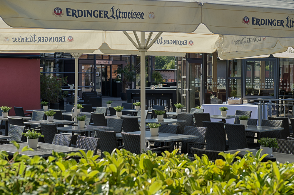 CFK - kleine Terrasse bestuhlt, mit Sonnenschirmen bei sonnigem Wetter